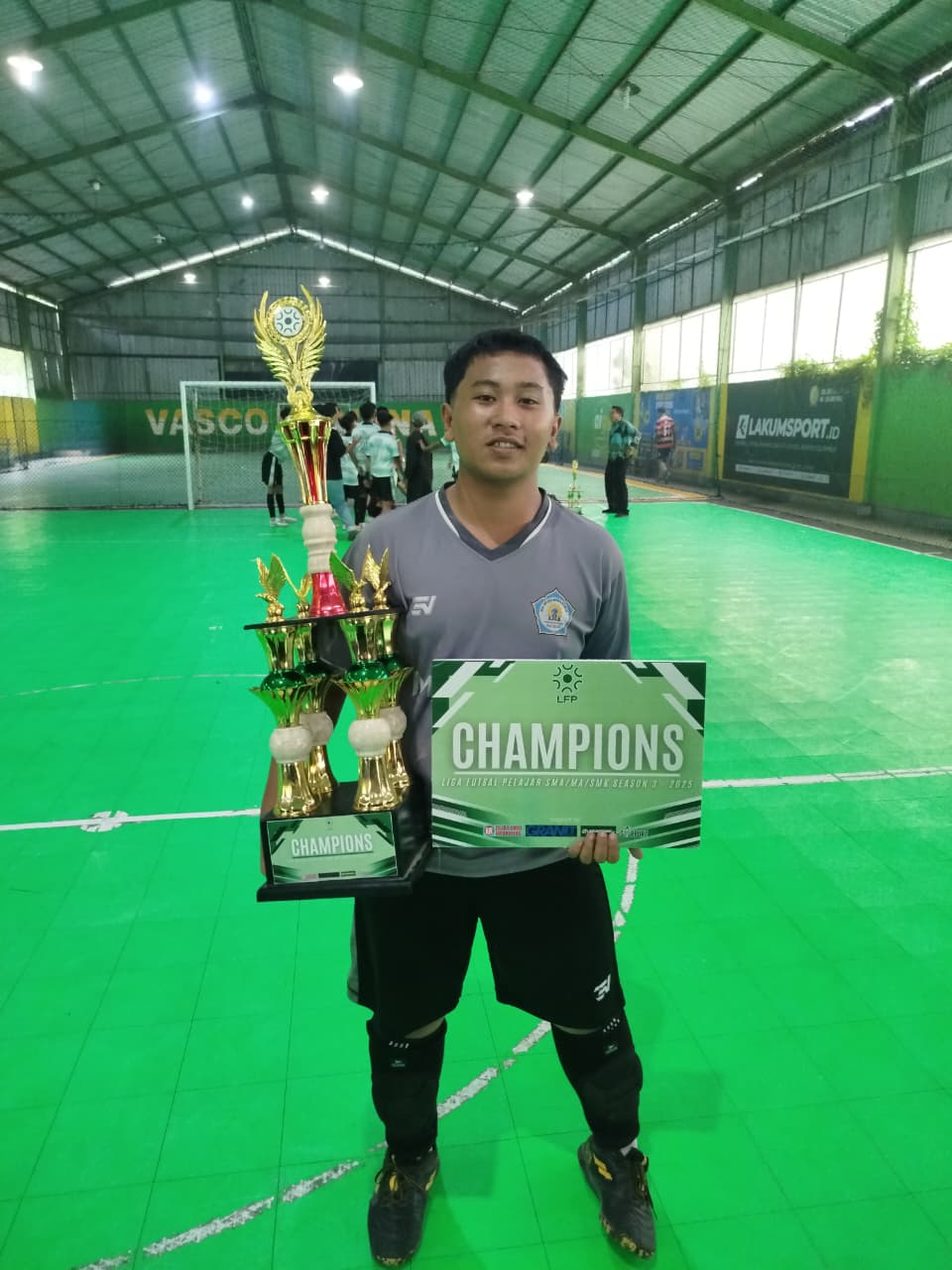 Foto Nazmi Ghaizan Al-Ghifari memegang trofi juara futsal